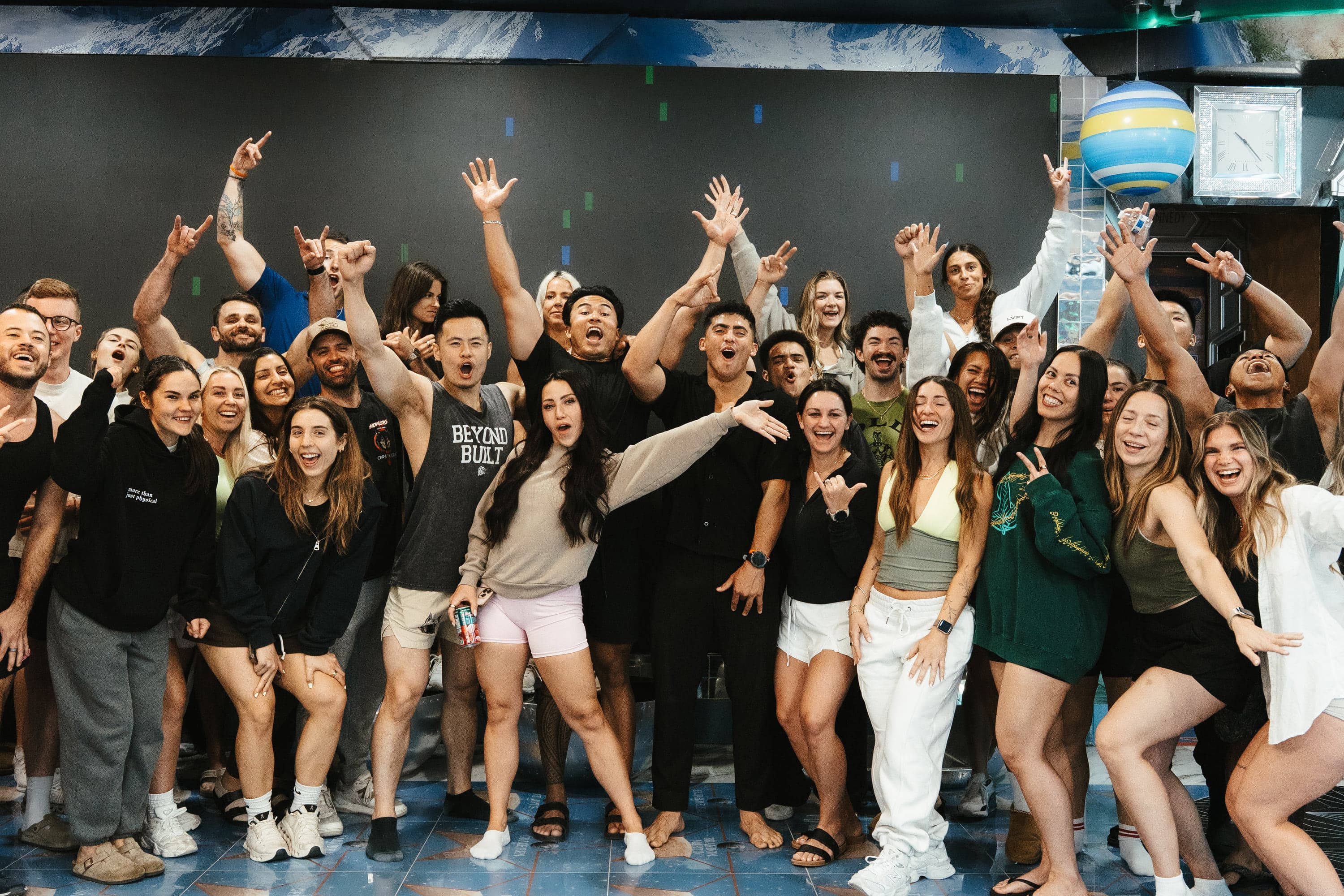 A large group celebrating together with arms raised at the close of a THRVE experience