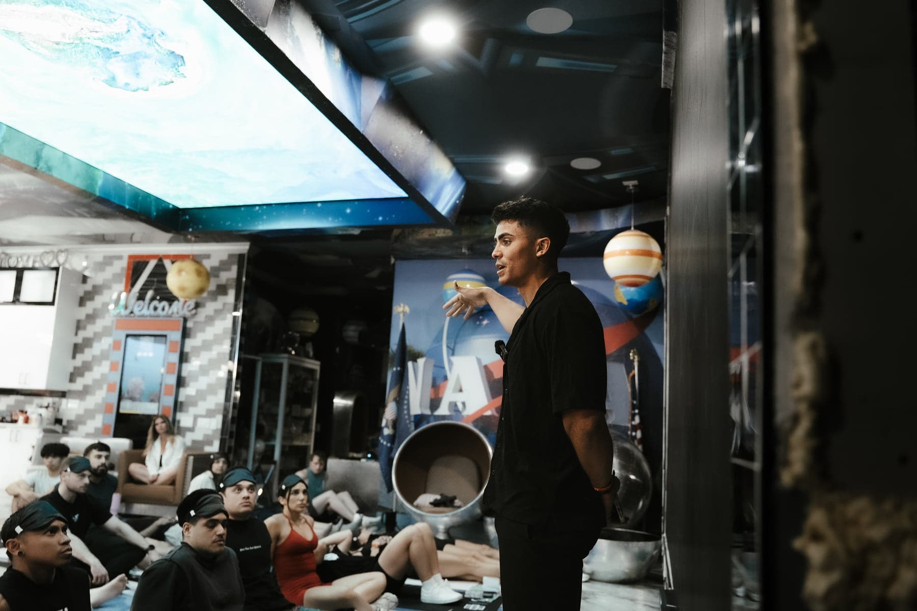 Jovany Ruiz speaking to a seated group inside an indoor training studio