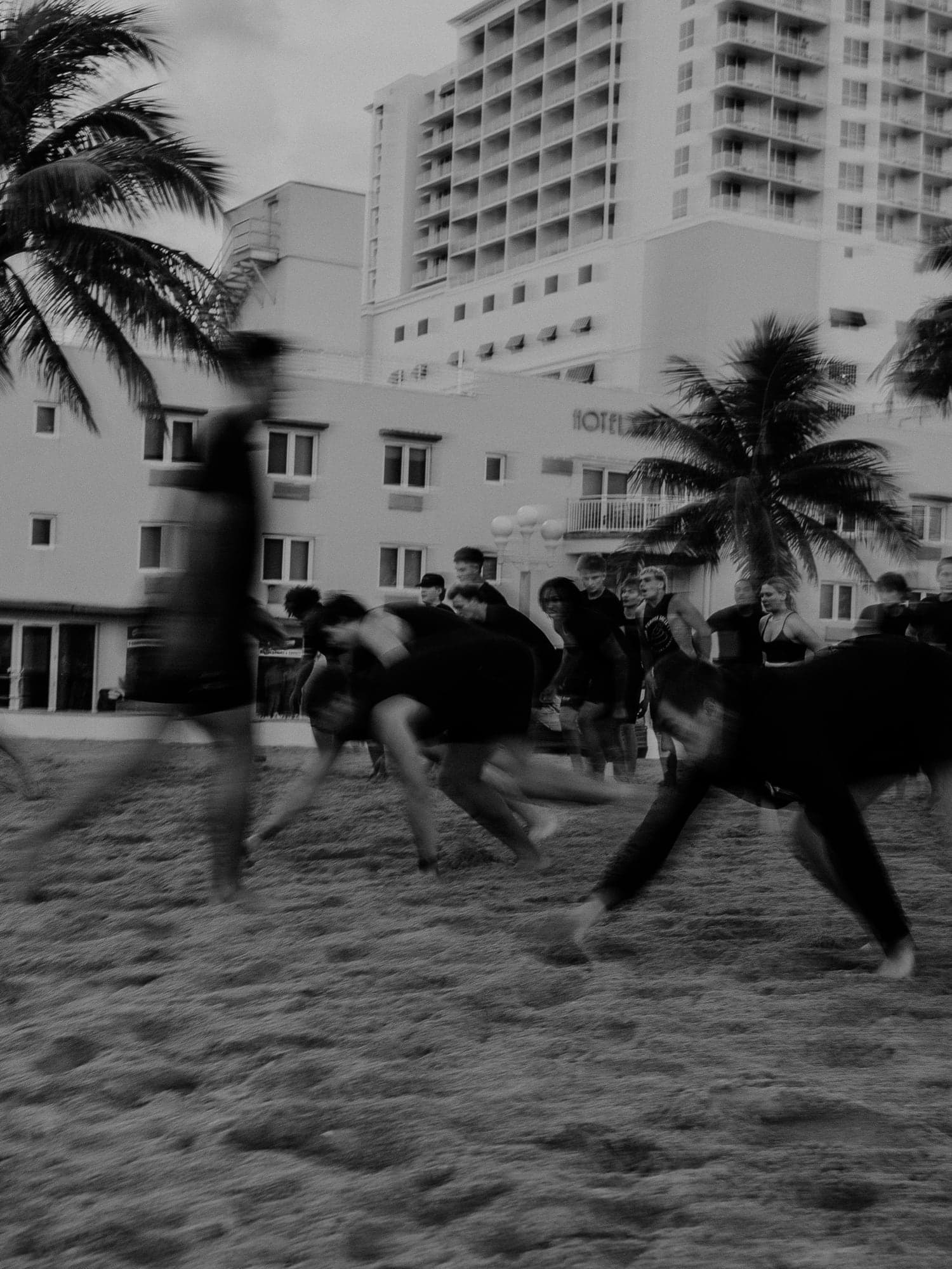 Black-and-white photograph of a group sprinting across the sand
