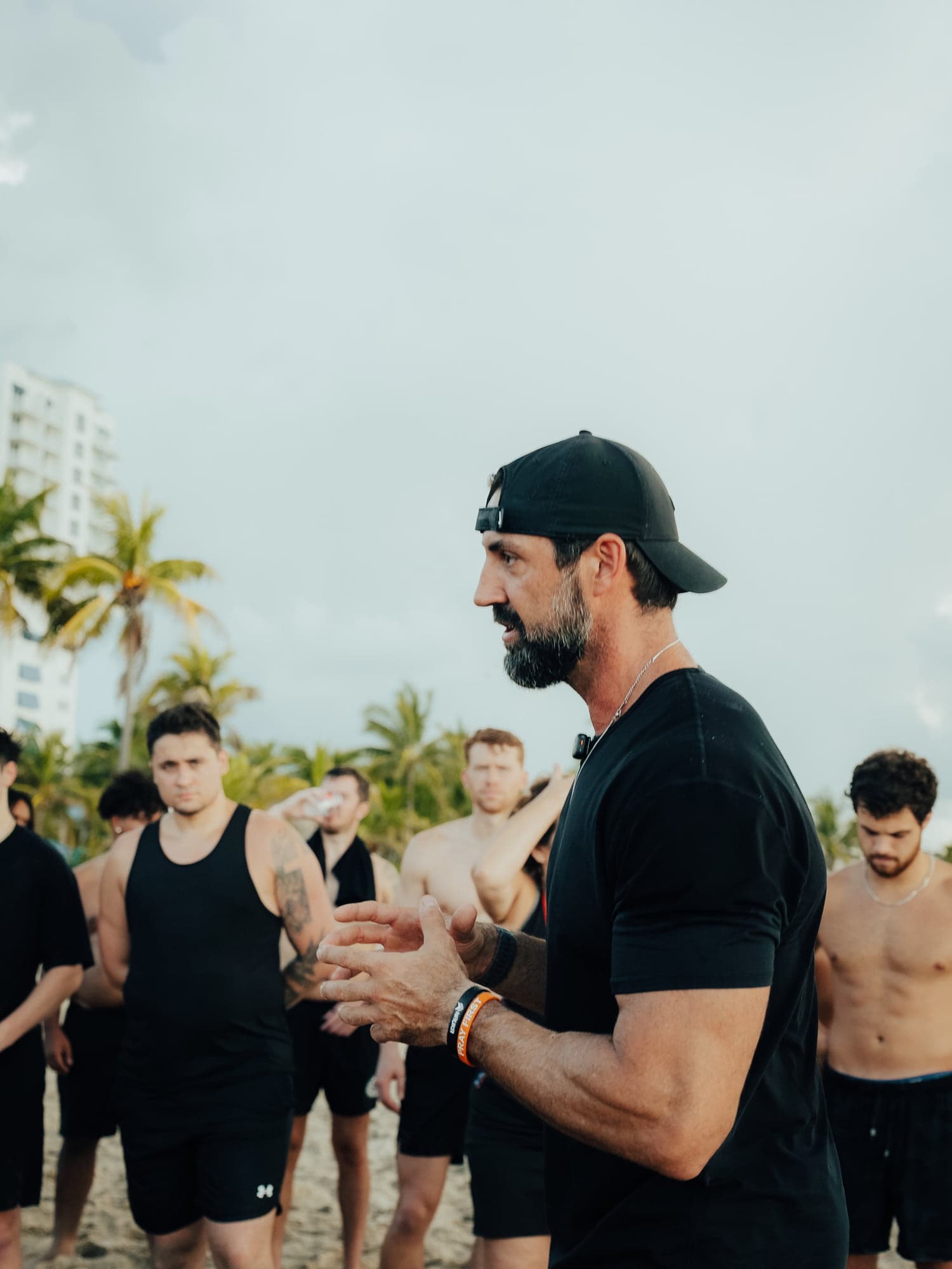A coach clapping to encourage the team during a beach session